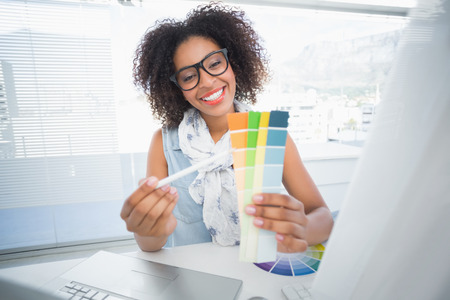 Pretty designer working at her desk in her officeの写真素材