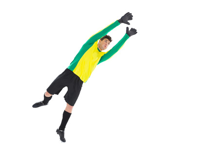 Goalkeeper in yellow jumping up on white backgroundの写真素材
