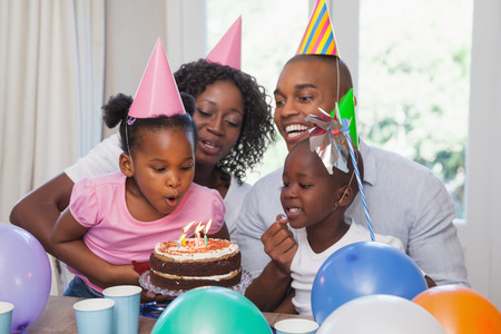 Happy family celebrating a birthday together at home in the kitchenの写真素材
