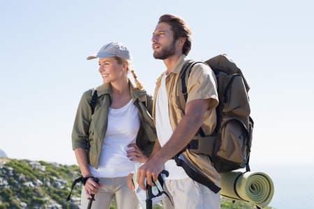 Hiking couple looking ahead at mountain summit on a sunny day