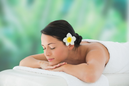 Beautiful brunette relaxing on massage table at a luxury spaの写真素材