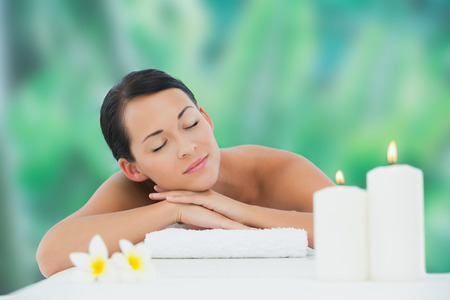 Beautiful brunette relaxing on massage table at a luxury spaの写真素材
