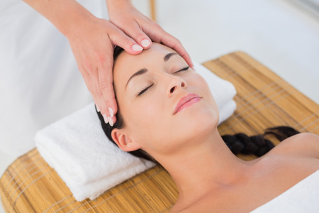 Beautiful brunette enjoying a head massage at a luxury spaの写真素材