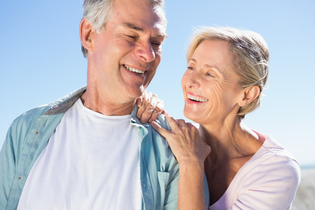 Happy senior couple embracing on the pier on a sunny day