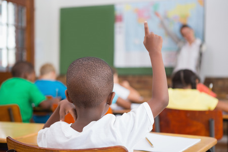 Pupil raising hand in classroom at the elementary schoolの写真素材