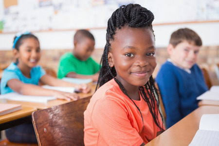 Cute pupils listening attentively in classroom at the elementary school