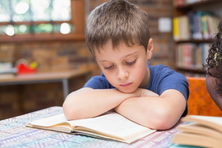 Cute pupils reading books in library at the elementary schoolの写真素材