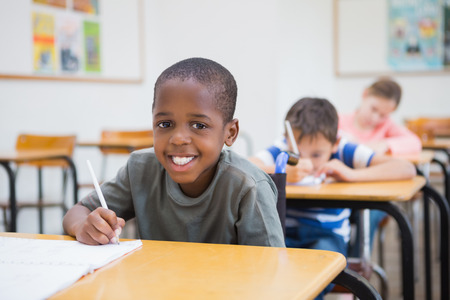 Disabled pupil writing at desk in classroom at the elementary schoolの写真素材