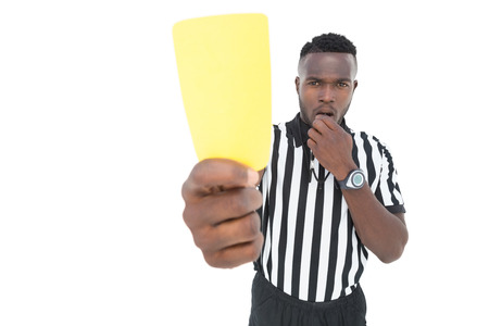 Serious referee showing yellow card over white backgroundの写真素材