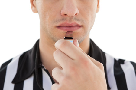 Close up mid section of referee blowing whistle on white backgroundの写真素材