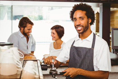 Barista grinding fresh coffee beans at the coffee shopの写真素材