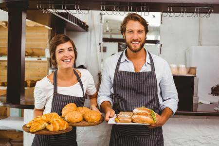 Happy servers holding plates of food at the coffee shopの写真素材