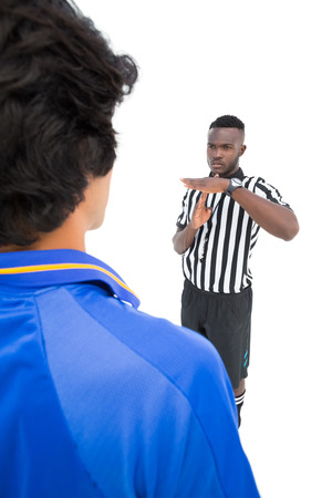 Serious referee showing time out sign to player over white backgroundの写真素材