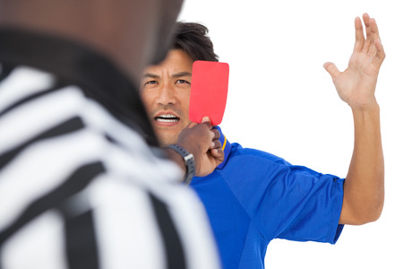 Referee showing red card to football player over white backgroundの写真素材