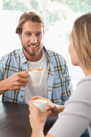 Happy couple enjoying a coffee at the coffee shopの写真素材