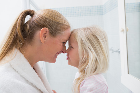 Happy mother and daughter smiling at home in the bathroomの写真素材