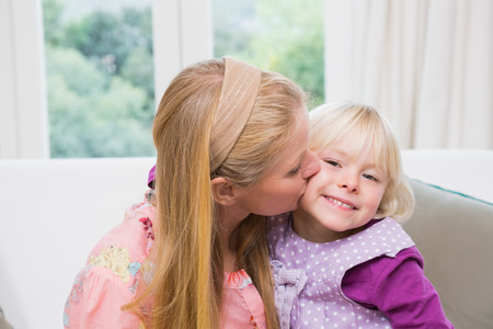 Happy mother and daughter on the couch at home in the living roomの写真素材
