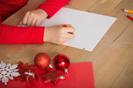 Little girl writing letter to santa at christmas at home in the living roomの写真素材