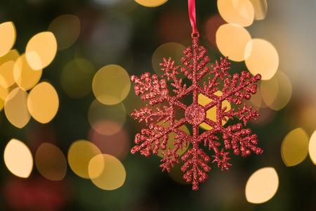Focus on red star christmas decoration on twinkling christmas treeの写真素材