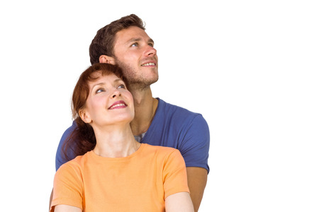 Happy couple together looking upwards on white backgroundの写真素材