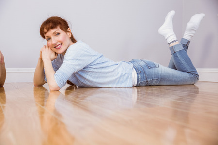 Woman lying on the floor and smilingの写真素材