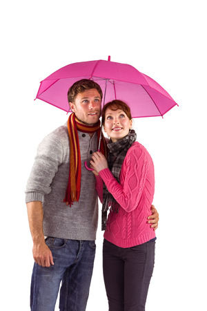 Couple standing underneath an umbrella on white backgroundの写真素材