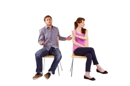 Sitting couple having an argument on white backgroundの写真素材