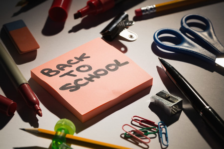 Students table with school supplies and a sticky note pad on itの写真素材