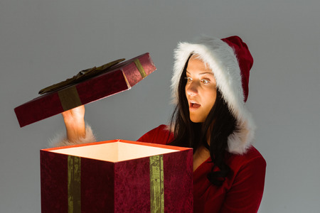 Surprised woman opening christmas present on white backgroundの写真素材