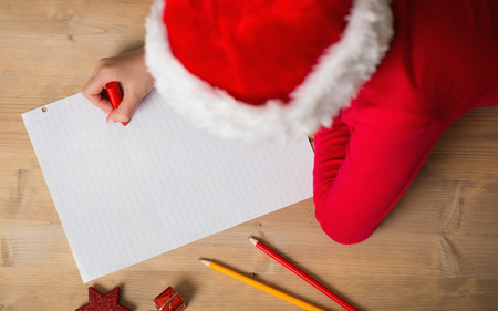 Little girl writing letter to santa at christmas at home in the living roomの写真素材