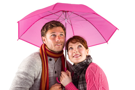 Couple standing underneath an umbrella on white backgroundの写真素材