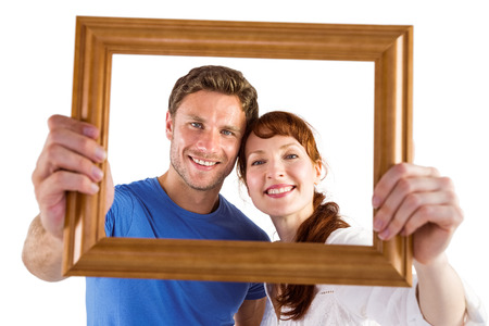 Couple holding frame ahead of them on white background