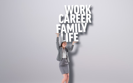 Businesswoman pushing up with hands against grey background with textの写真素材