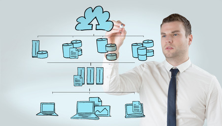 Young businessman writing with marker against grey vignetteの写真素材