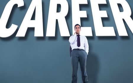 Unsmiling businessman standing against grey background with textの写真素材