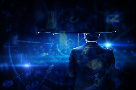 Mature businessman holding an umbrella against blue background with lettersの写真素材