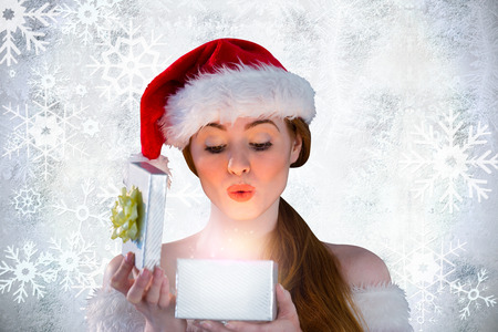 girl in santa costume opening a gift against silver snow flake pattern design