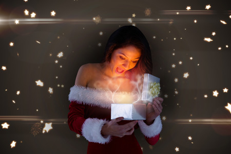 santa girl opening gift against bright star pattern on black