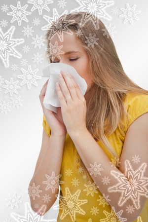 Close up of a blond woman blowing against snowflakes on silverの写真素材