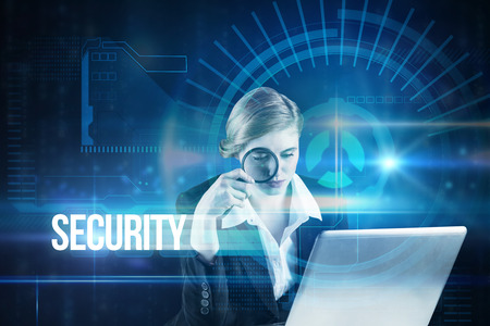 The word security and redhead businesswoman using her laptop against blue technology interface with...