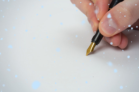 Hand writing with fountain pen against snow falling