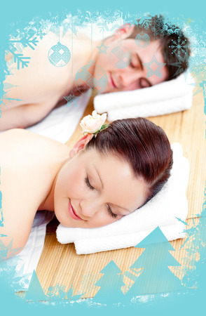 Resting couple lying on a massage table against christmas frameの写真素材