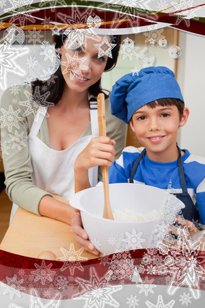 Mother and son preparing cookies against christmas frameの写真素材