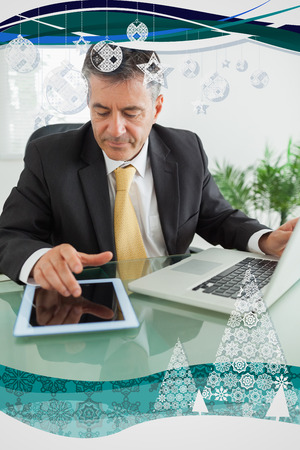 Business man working on digital tablet against christmas frameの写真素材