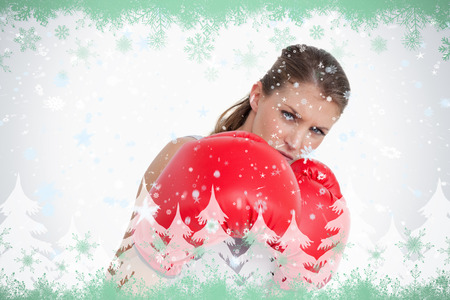 Composite image of ports woman boxing against green snowflake designの写真素材
