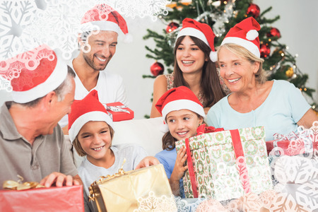 Happy family at christmas swapping gifts against snowflake frame