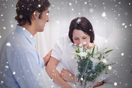 Composite image of man brought flowers to his girlfriend in the hospital against snow fallingの写真素材