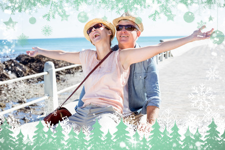 Happy casual couple going for a bike ride on the pier against snowの写真素材