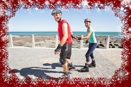 Fit mature couple rollerblading on the pier  against snowの写真素材