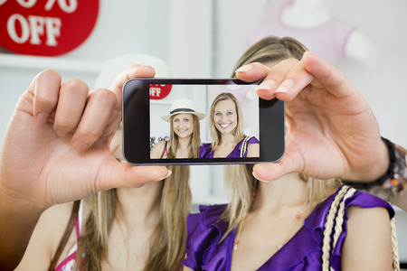 Composite image of hand holding smartphone showing photograph